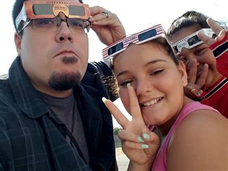 people posing with solar viewing glasses