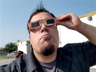 man wearing solar viewing glasses