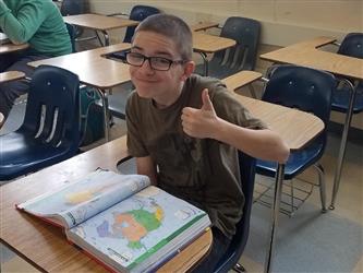 student holding thumbs up