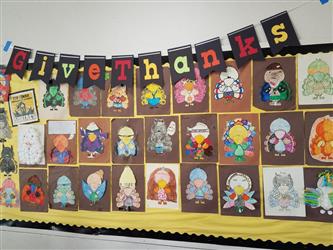 wall of artwork with text give thanks