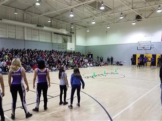 people standing in gym in front of students