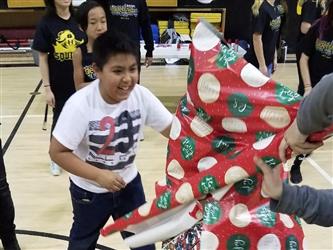 students getting wrapped in gift paper
