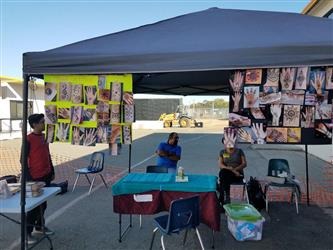 students standing under popup tent
