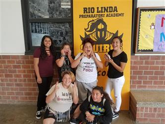 people posing in front of school banner