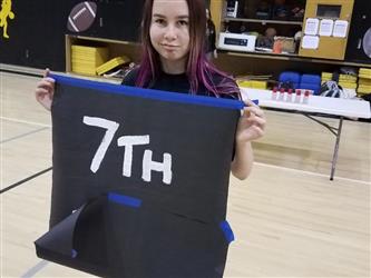 student holding 7th sign