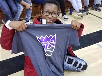 student holding sacramento kings shirt