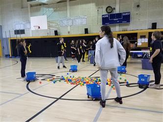 people standing around buckets and balls on the ground