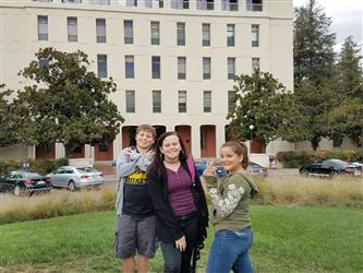 students posing in front of building