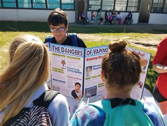 people looking at student presentation regarding the dangers of vaping