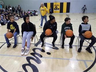 students in chairs holding basketballs