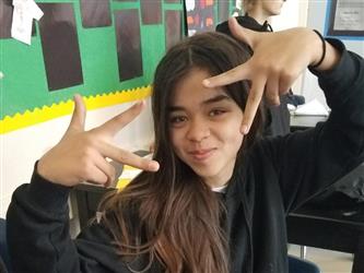 student holding fingers up for camera