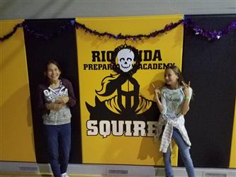 students posing in front of rio linda squires wall