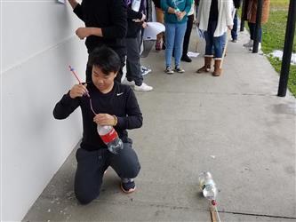 student holding two liter bottle