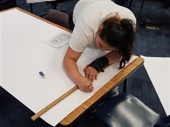 student using ruler to make poster